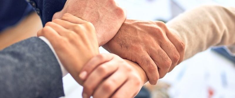 person in black long sleeve shirt holding persons hand